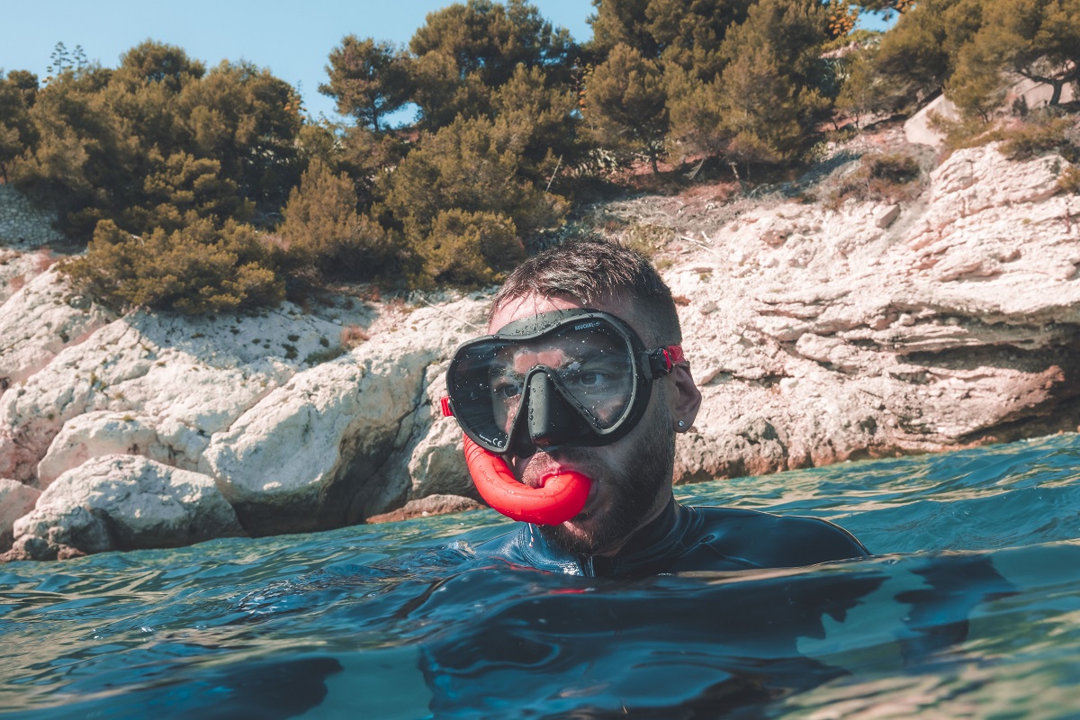 Un homme faisant du snorkeling porte un masque de plongée Maxlux S Bicolore et un tuba Spy Beuchat.